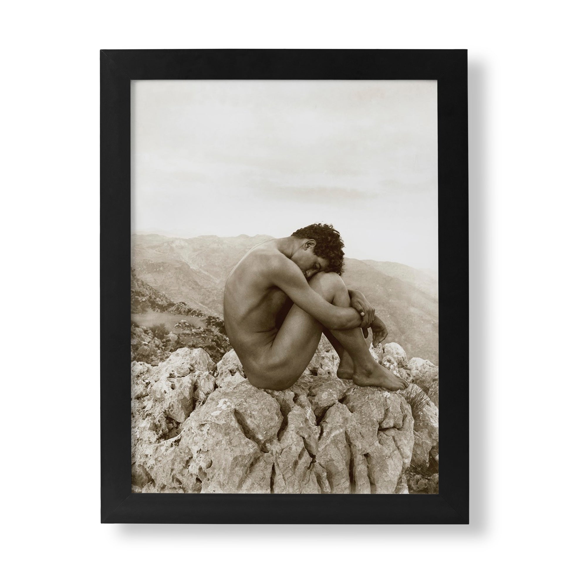 Wilhelm von Gloeden "Cain" photography print, a fine art piece depicting a solitary, curled nude male figure on a rugged rock outcrop, with a sepia-toned landscape background.