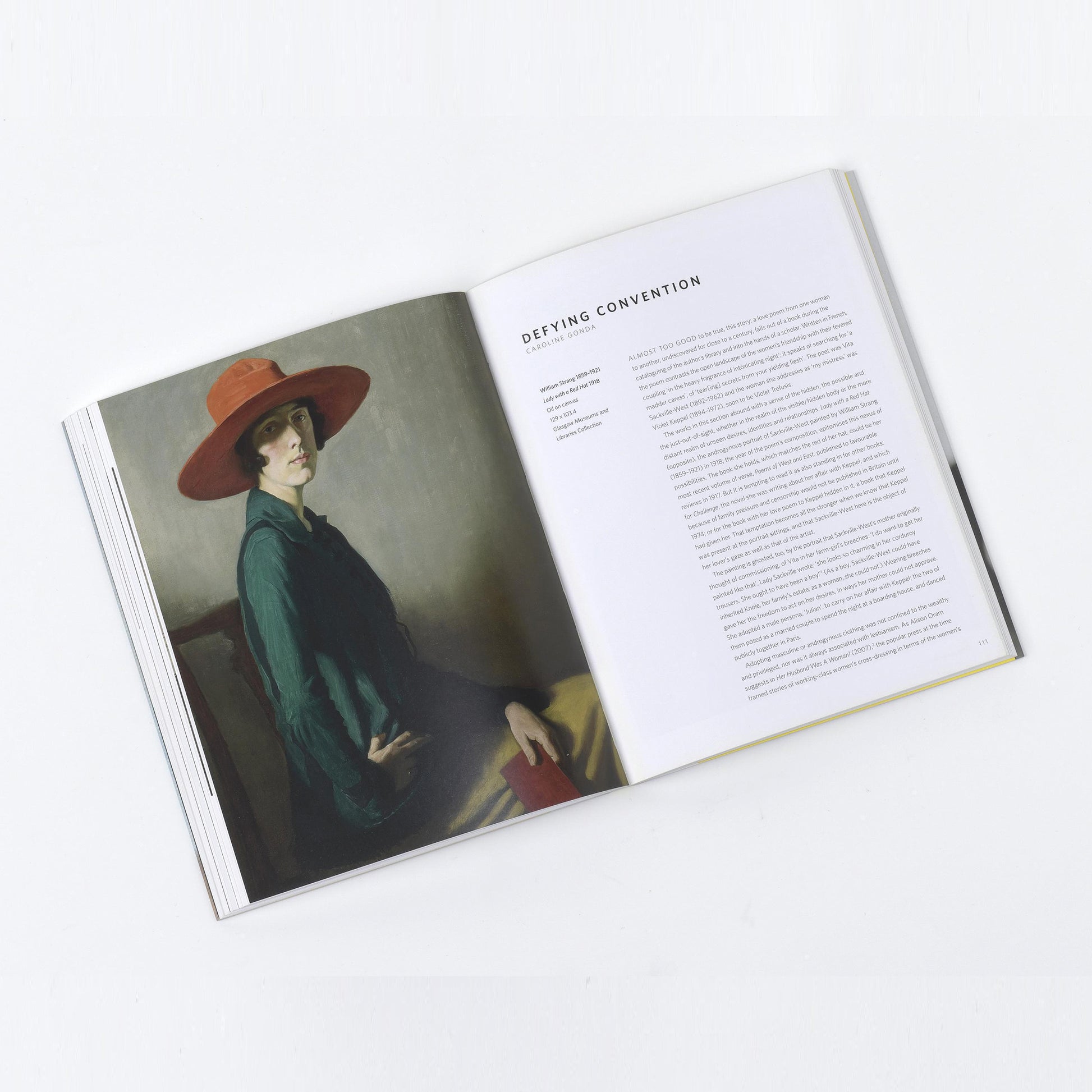 Interior shot of the Queer British Art volume, displaying a striking portrait of a woman in a red hat by Glyn Philpot.