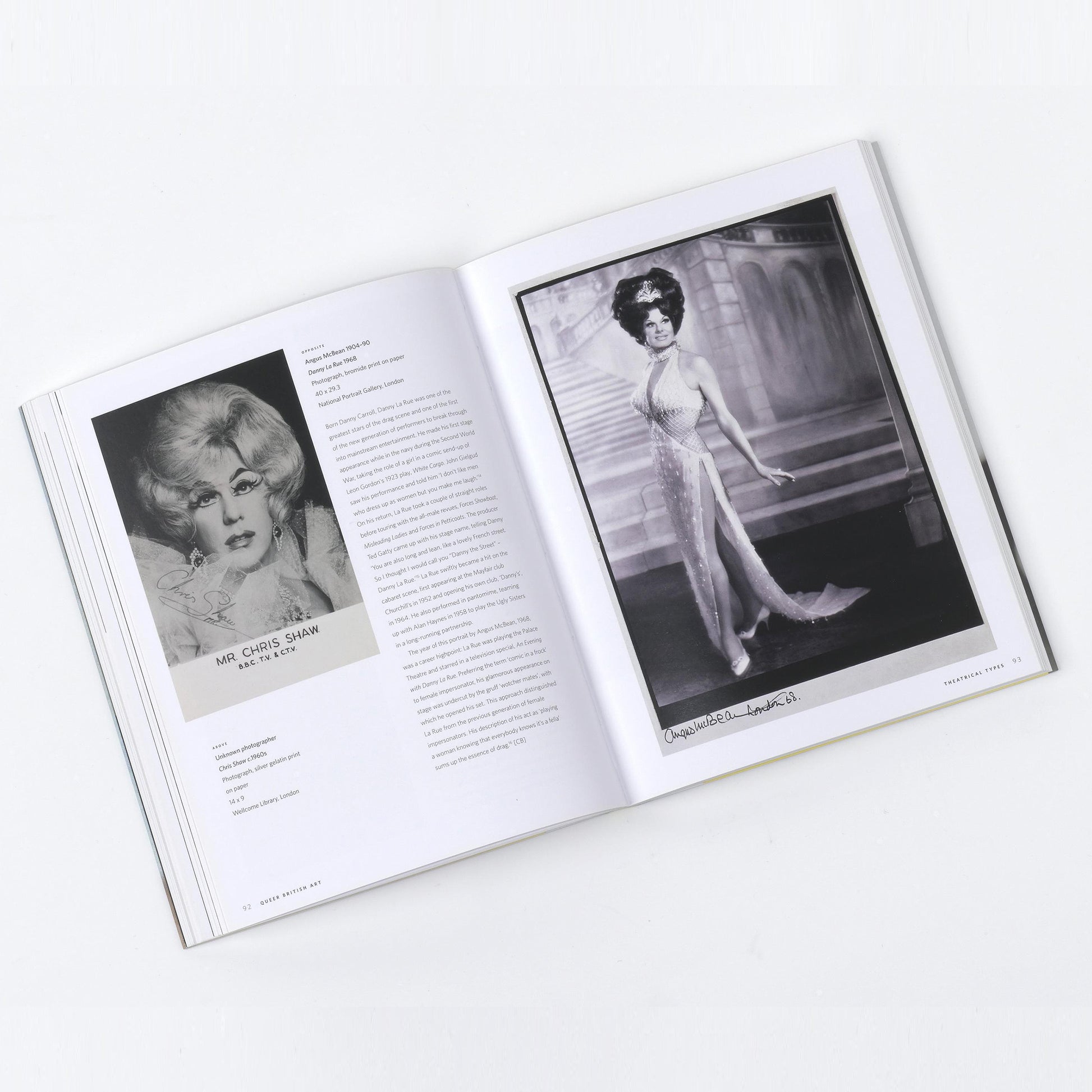 A two-page spread from the Queer British Art catalogue, showing a portrait of Mr. Chris Shaw and a black and white photograph of a drag queen performance.