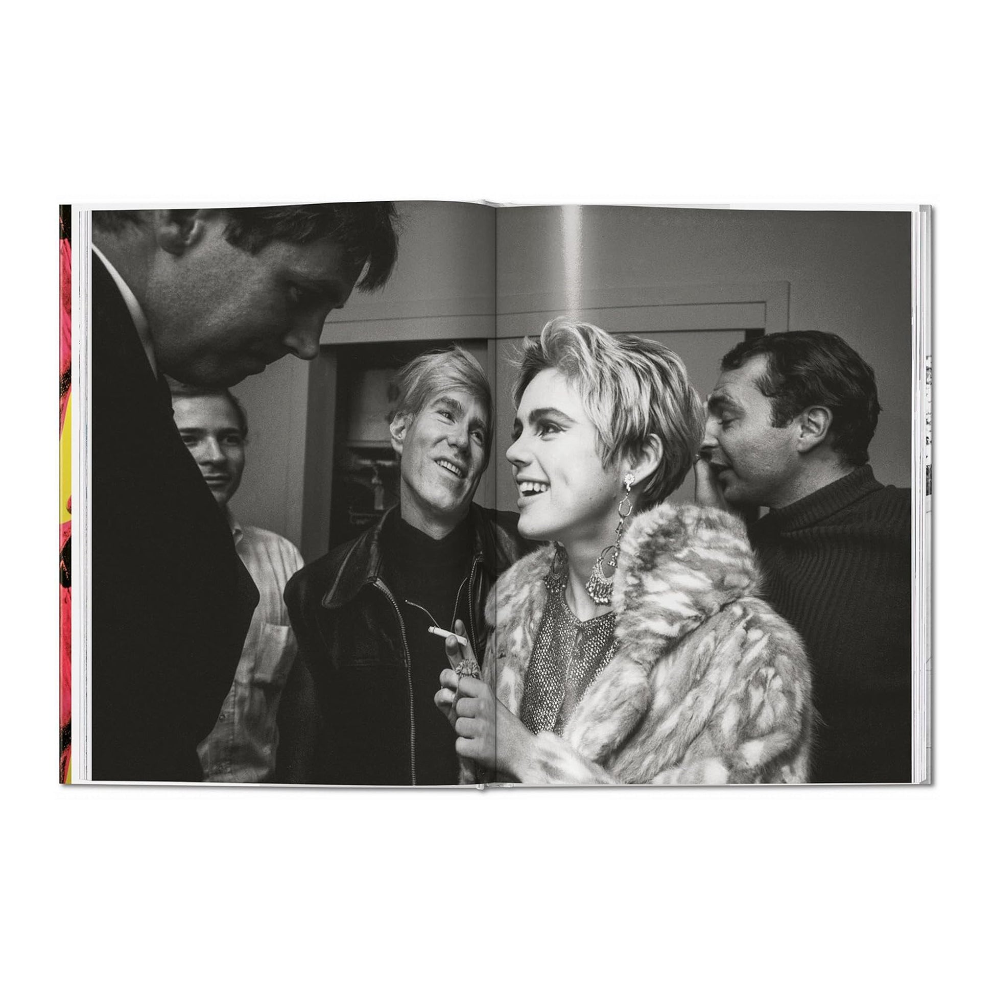 A page spread from the book featuring a black and white fine art photograph by Steve Schapiro of Andy Warhol and Edie Sedgwick at an art opening.