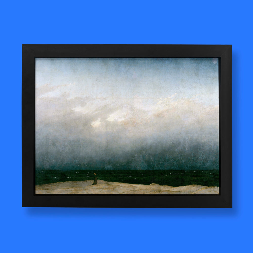 Caspar David Friedrich Monk by the Sea fine art print, featuring a solitary robed figure standing on a sandy shore before a vast, stormy ocean and dramatic grey sky