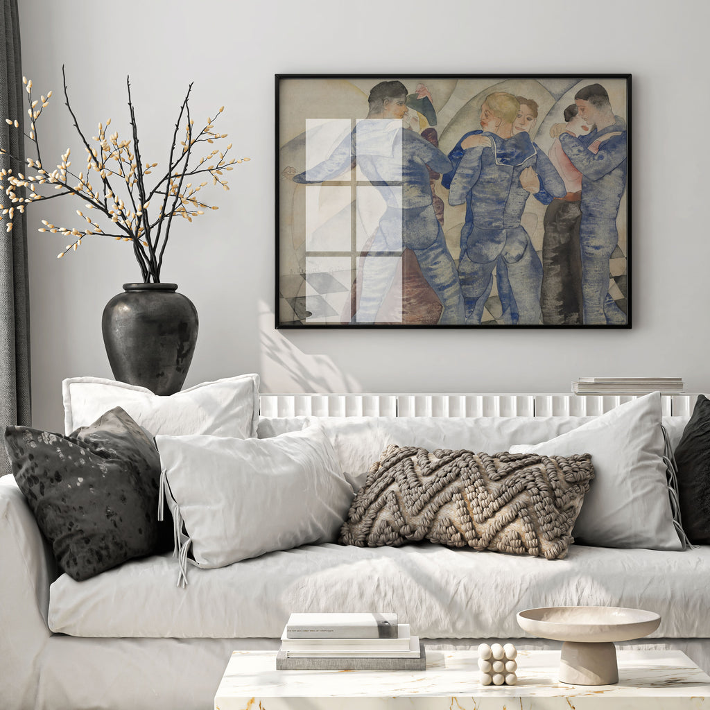 A framed art print depicting four figures in blue suits hangs on a light gray wall above a white sofa styled with neutral-toned pillows and a dark vase with dried branches.