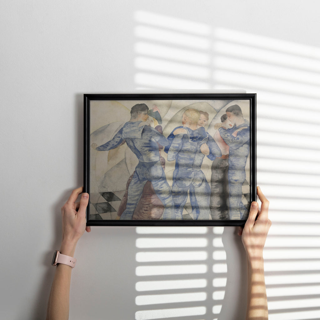 A person holds a black-framed art print against a light gray wall, with soft window-blind shadows cast across the artwork and wall. The print depicts three figures in blue clothing in a muted, painterly style.