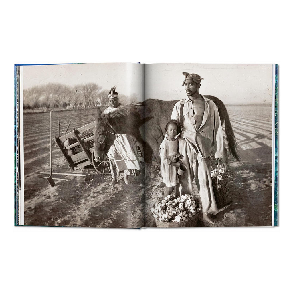 A black and white photograph from the David LaChapelle art book, depicting a man and a girl with a horse and basket of cotton in a field. The man is Tupac Shakur.