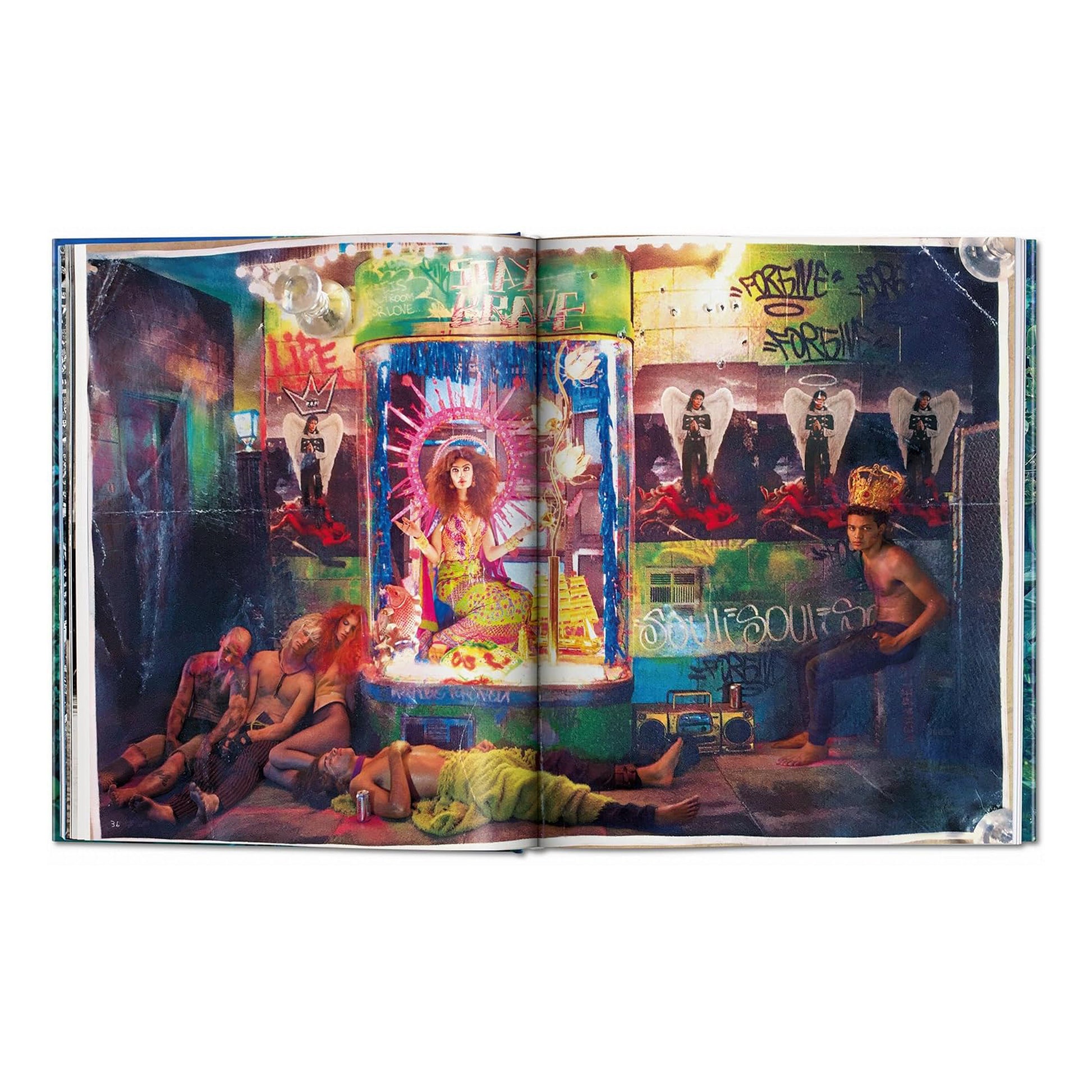 A double-page spread from the David LaChapelle Good News hardcover book, showing a vibrant, surreal scene in an urban-style room with a person sitting in a glass tube and other figures on the floor.