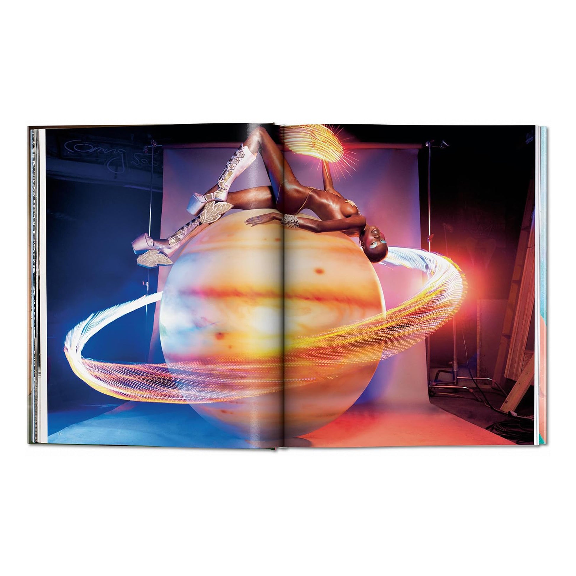 A striking image from the David LaChapelle collection featuring a person wearing futuristic boots and jewelry, lying on a large, glowing planet.