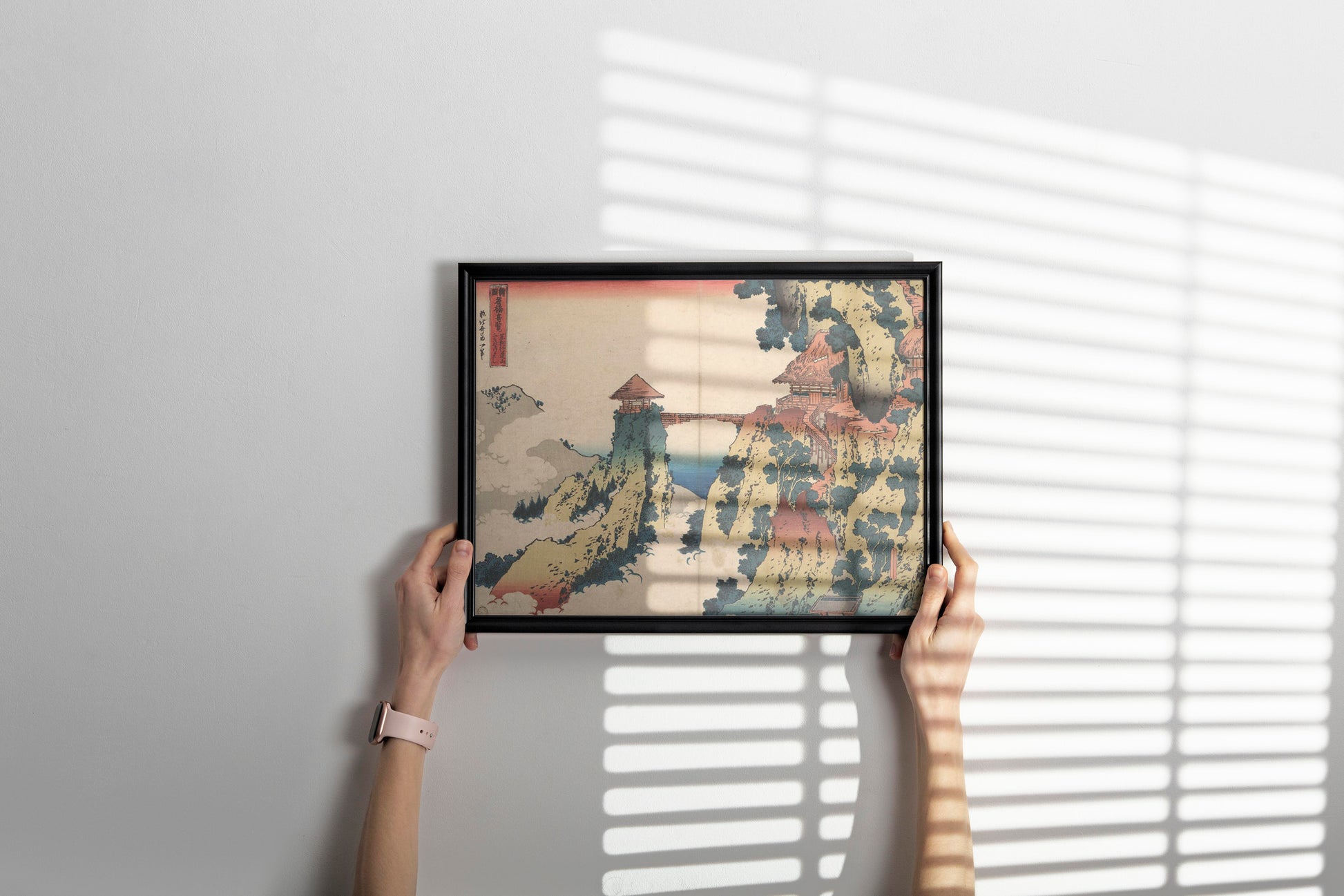 Framed Japanese ukiyo-e art print by Hokusai featuring dramatic mountain bridge landscape, perfectly styled wall decor showcasing traditional fine art in contemporary living space interior design