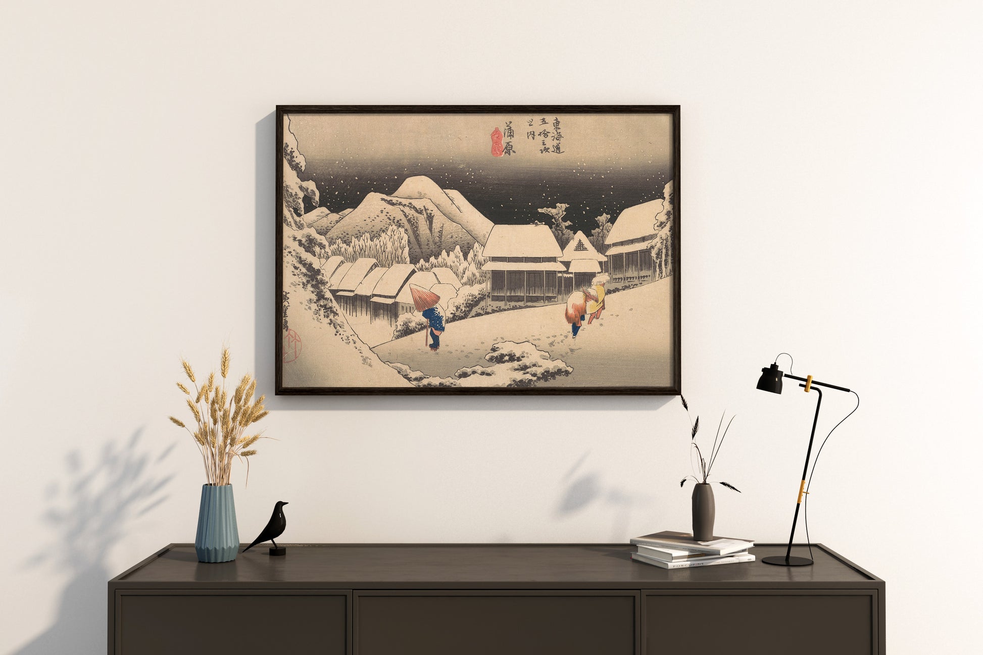 A beautiful framed art print of Hiroshige's A Snowy Evening at Kambara Station, a classic Japanese Ukiyo-e woodblock print, hanging on a wall as stylish home decor.