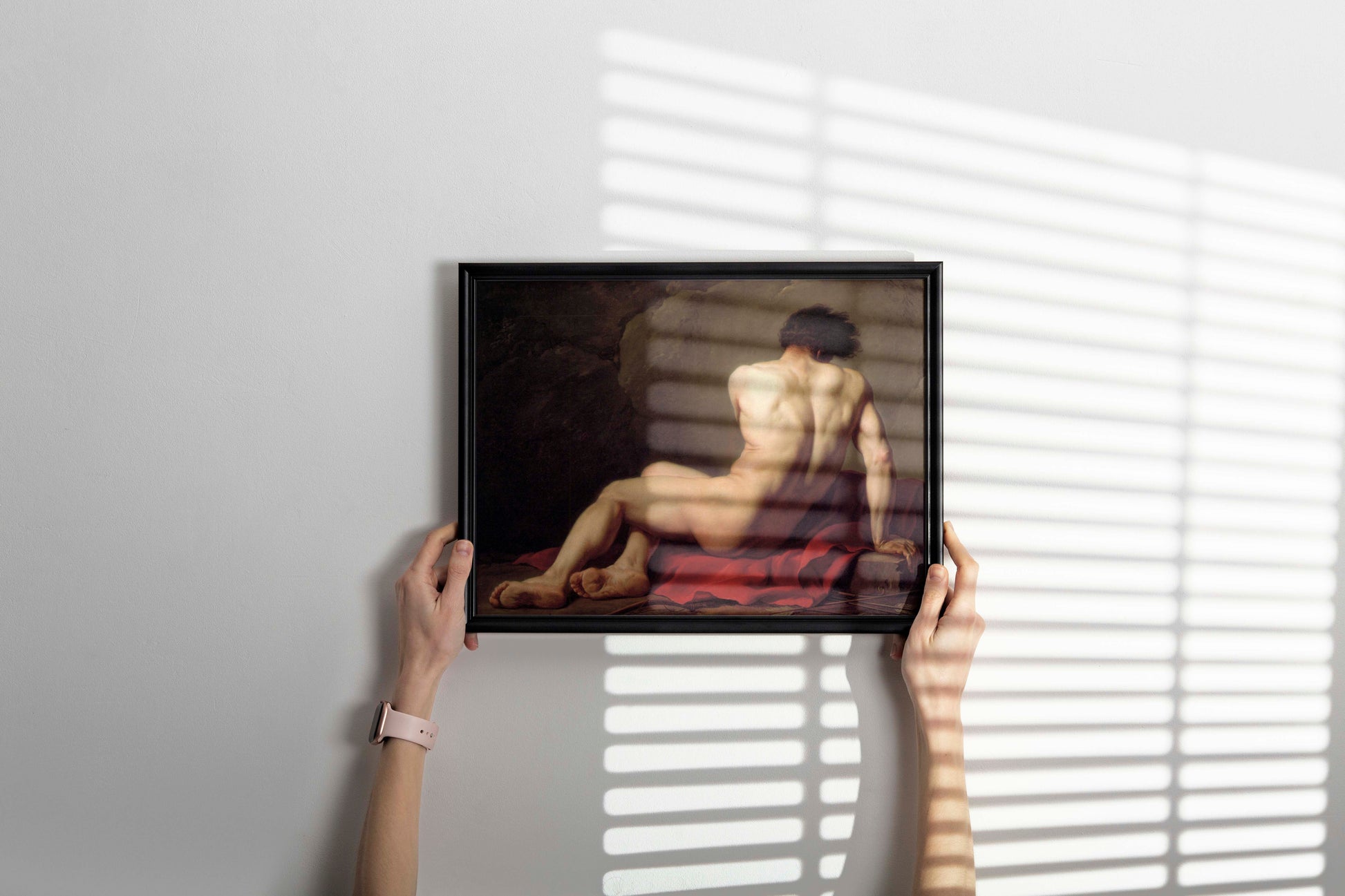 Framed artwork of a nude Patroclus on a white wall with blinds casting shadows.