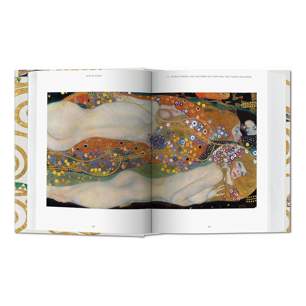 A two-page spread from the luxury Gustav Klimt coffee table book, featuring a detailed painting of reclining nudes with vibrant patterns and gold accents. High-quality reproductions of fine art.