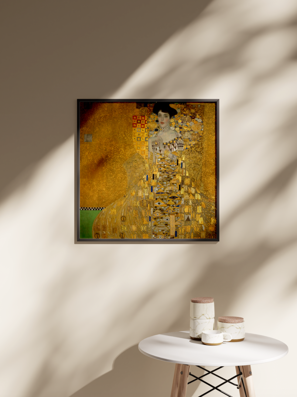 A framed Gustav Klimt "Portrait of Adele Bloch-Bauer I" art print hangs on a sunlit wall in a modern room, showcasing how the golden masterpiece looks as stylish home decor.