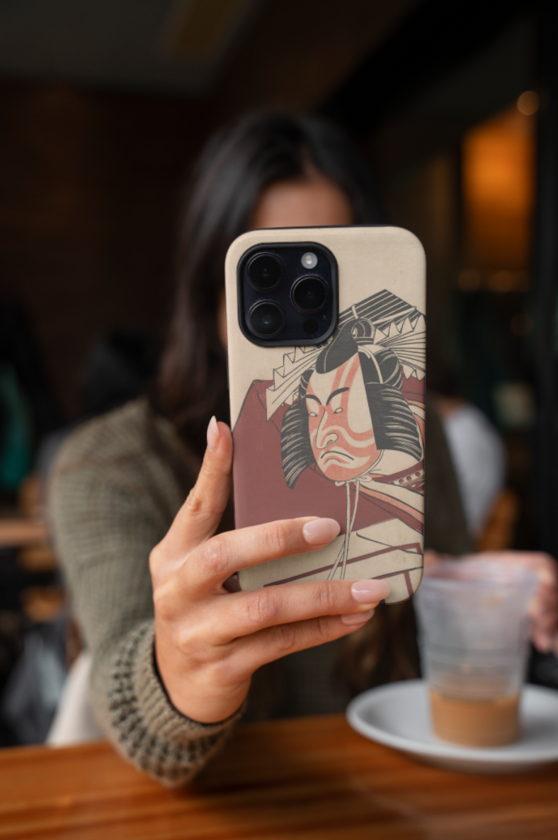 Person holding a phone with a unique case in a blurred indoor setting