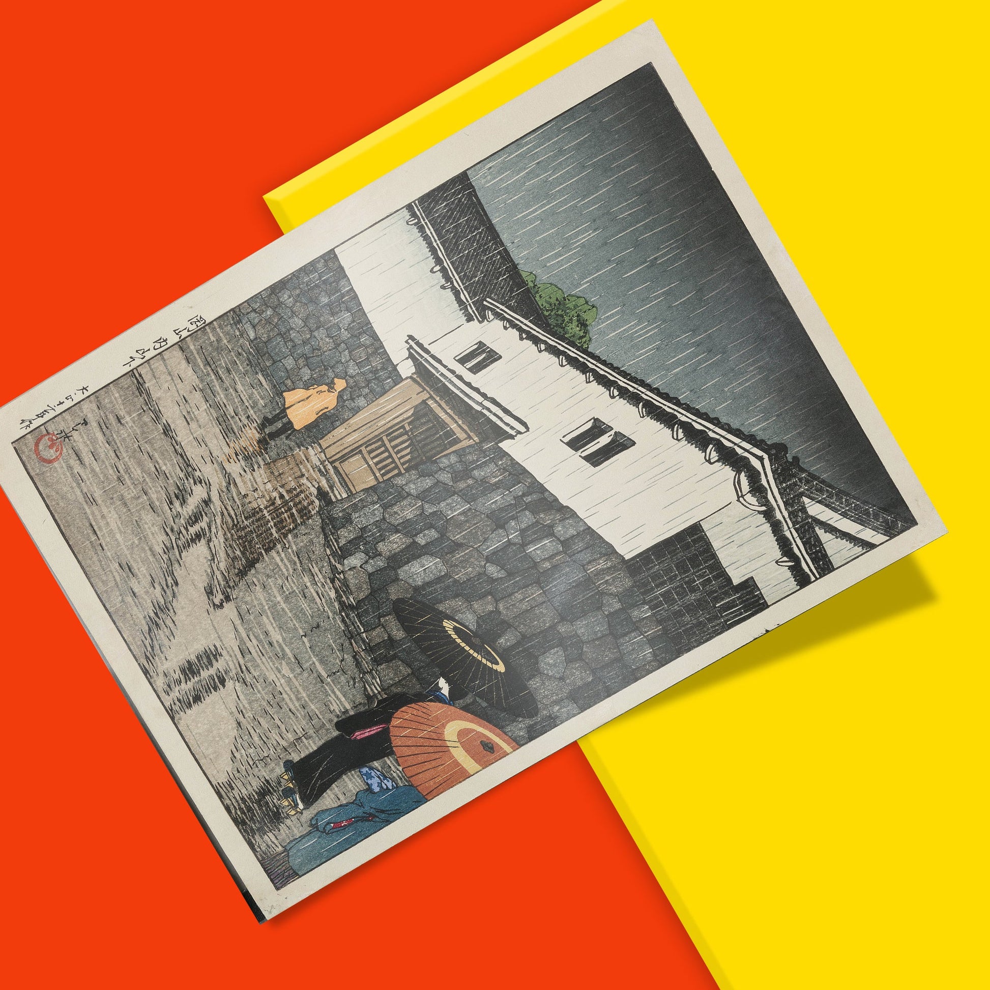 Japanese art print of a atmospheric rain scene by shin-hanga master Hasui Kawase showing reflections on wet cobblestones and traditional architecture