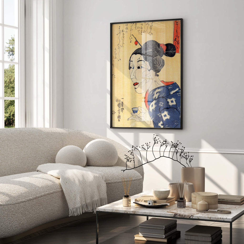 A black framed Utagawa Kuniyoshi fine art print, "Even Though She Looks Old, She Is Really Young," mounted on a white wall above a beige sofa in a sunlit living room, ideal for modern home decor.