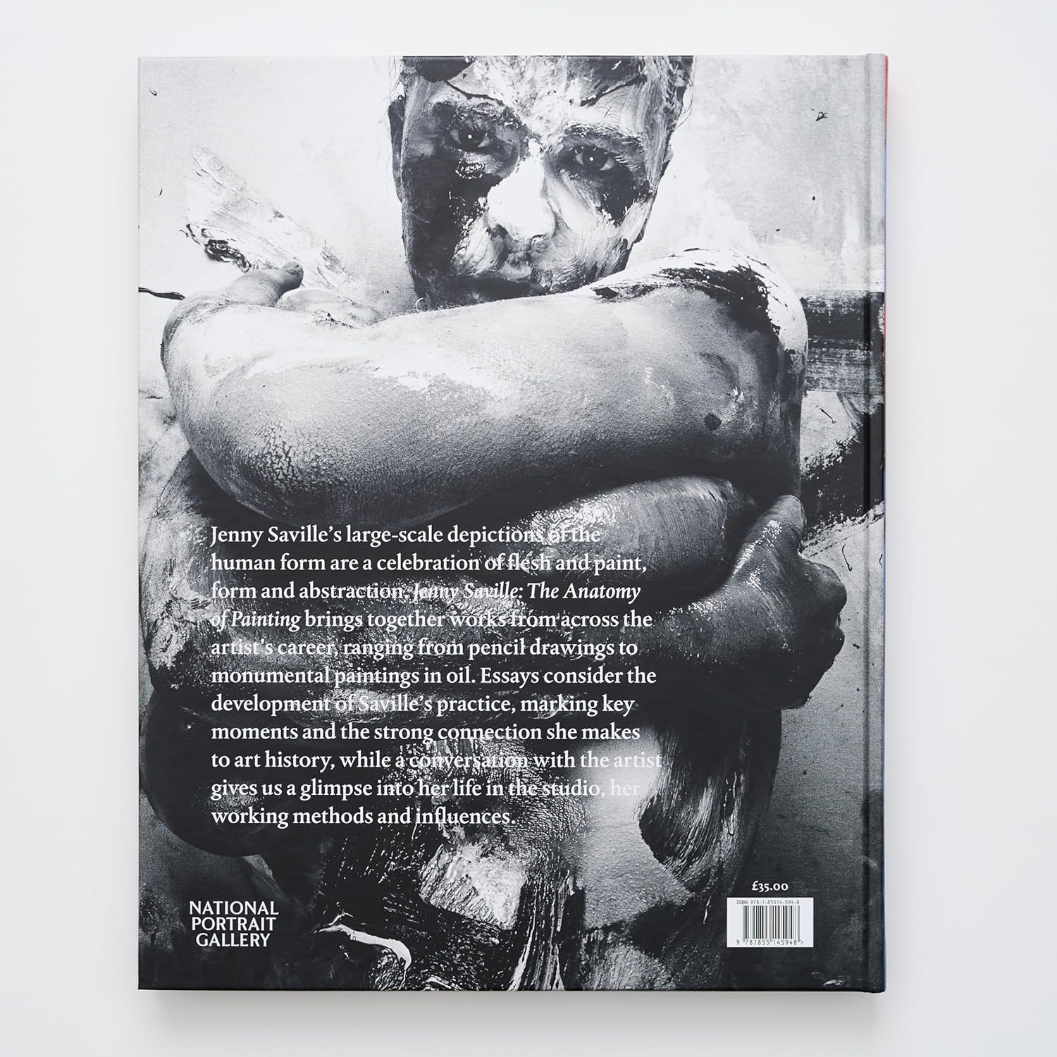 The back cover of the 'Jenny Saville' hardcover art book. A black and white photograph of a man with his body covered in paint is featured, along with a description of the book's content and its focus on the artist's career, from drawings to monumental oil paintings.