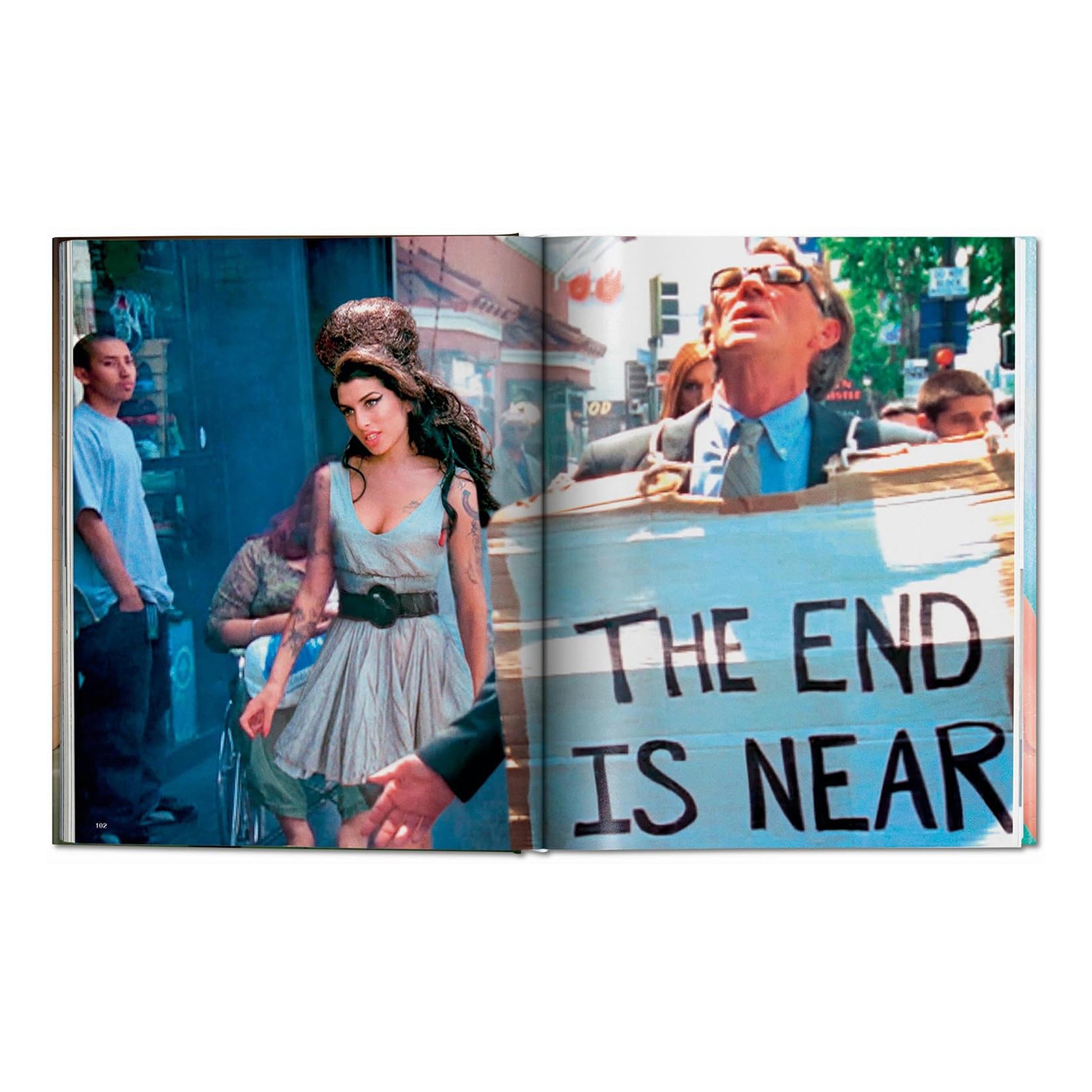 Editorial photography by David LaChapelle of Amy Winehouse walking down a street with a man holding a "The End is Near" sign.