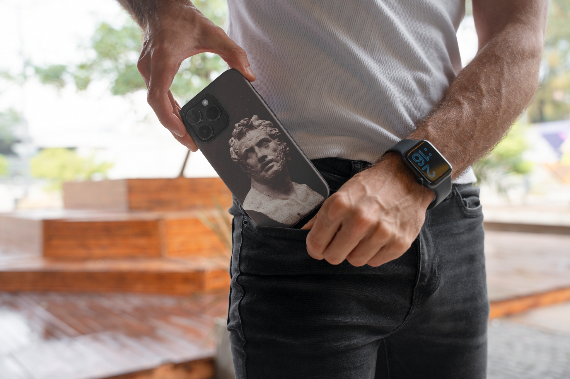 A man putting an iPhone with the ART SNOB 'Bust of Patroclus' fine art phone case into his jeans pocket, showcasing the phone's sleek design and the historical art print in a casual, lifestyle context.