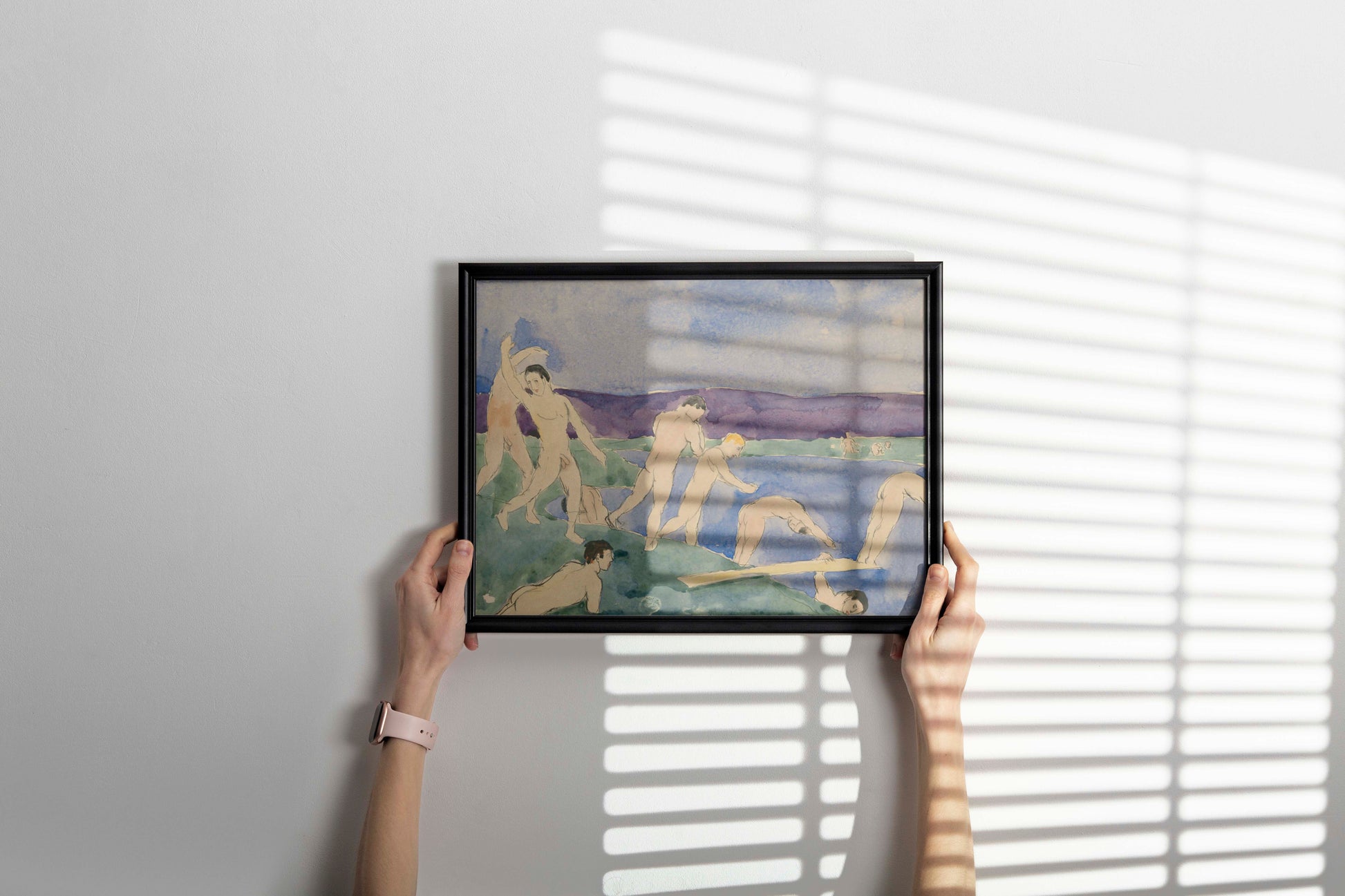 A wide shot of a contemporary living room showing a framed giclée print of Charles Demuth's famous queer art piece "Twelve Nude Men at the Beach" hanging as a focal point.