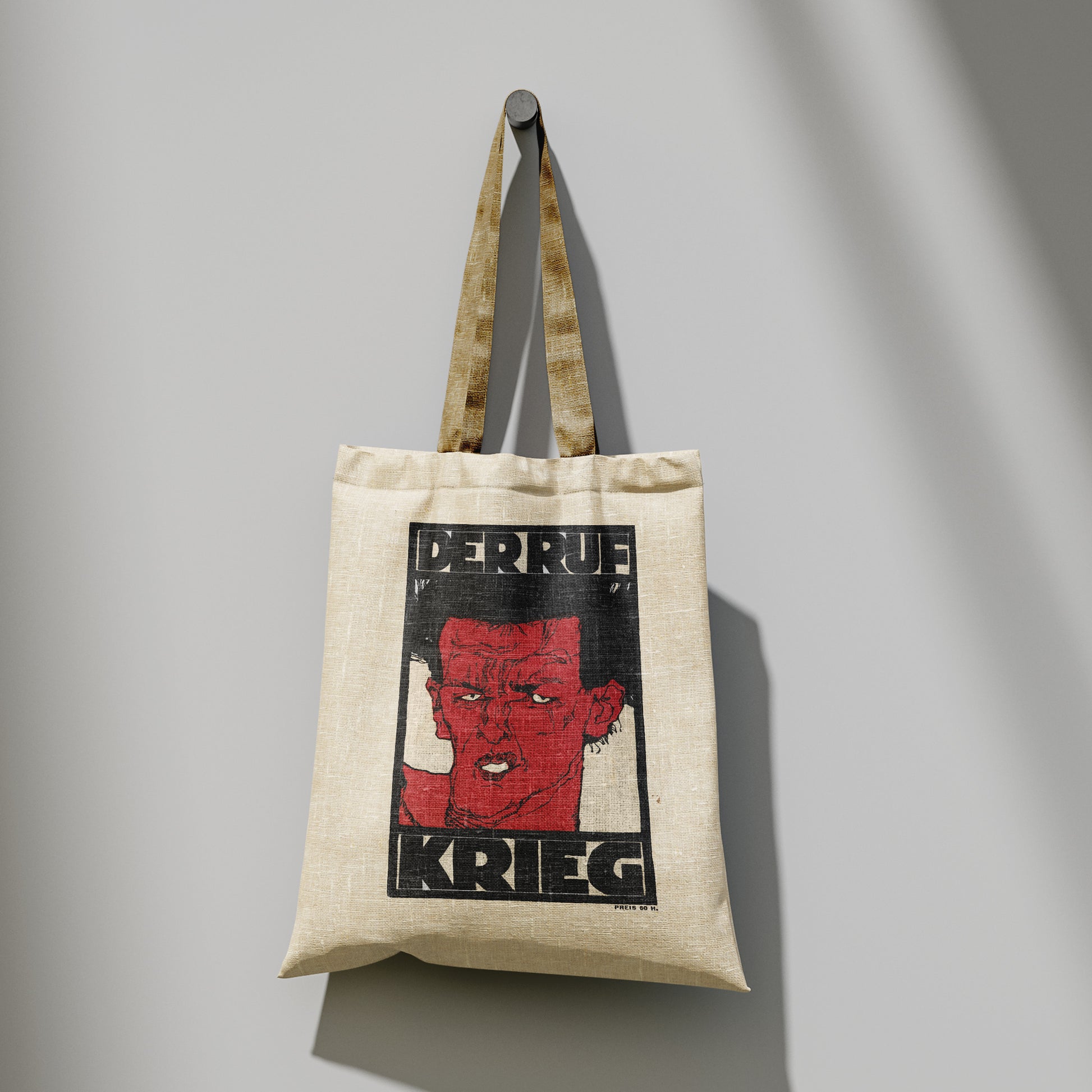 Close-up of the reinforced stitching on the long handles of a 100% cotton art tote bag featuring the Der Ruf magazine artwork.