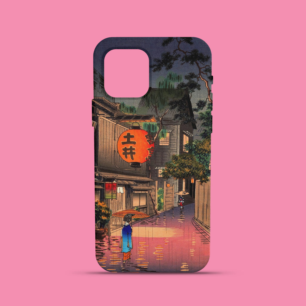 A phone case featuring a Shin-hanga Japanese woodblock print by Tsuchiya Koitsu titled 'Evening at Ushigome.' The art depicts a person with a traditional umbrella walking down a wet, rainy street at night, with warm light from a large red lantern reflecting on the ground.
