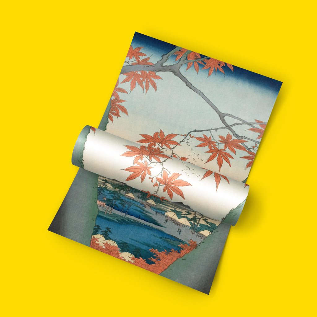 A rolled sheet of decorative print featuring a Japanese-style autumn landscape print with red maple leaves, blue water, and white clouds, displayed on a solid bright yellow background.