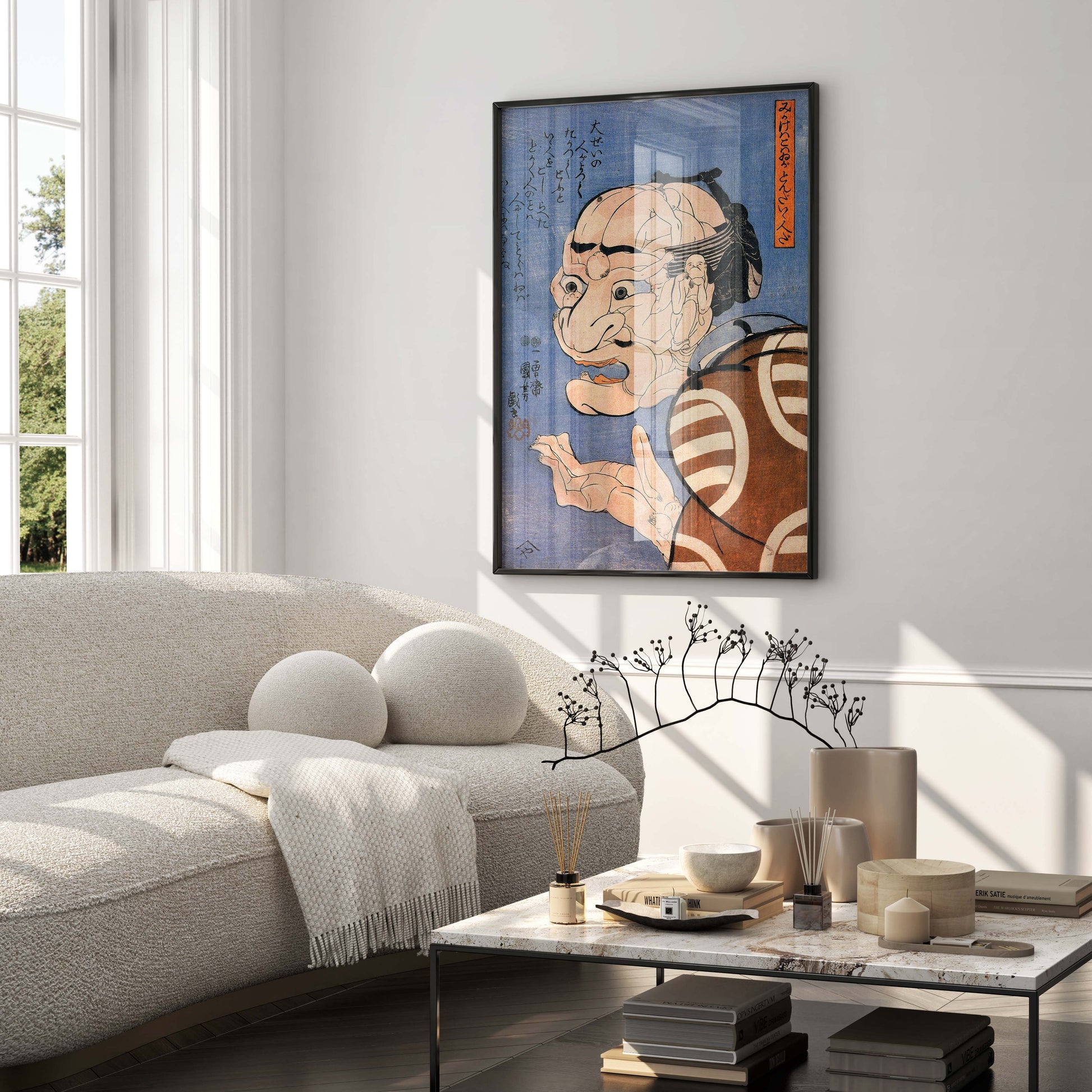 A classic Utagawa Kuniyoshi print, "At first glance he looks fierce, but he is really a kind person," beautifully displayed in a black frame as a key piece of wall art in a contemporary, sunlit living room. The Japanese art print enhances the modern home decor, positioned stylishly above a marble coffee table and a neutral-toned sofa.