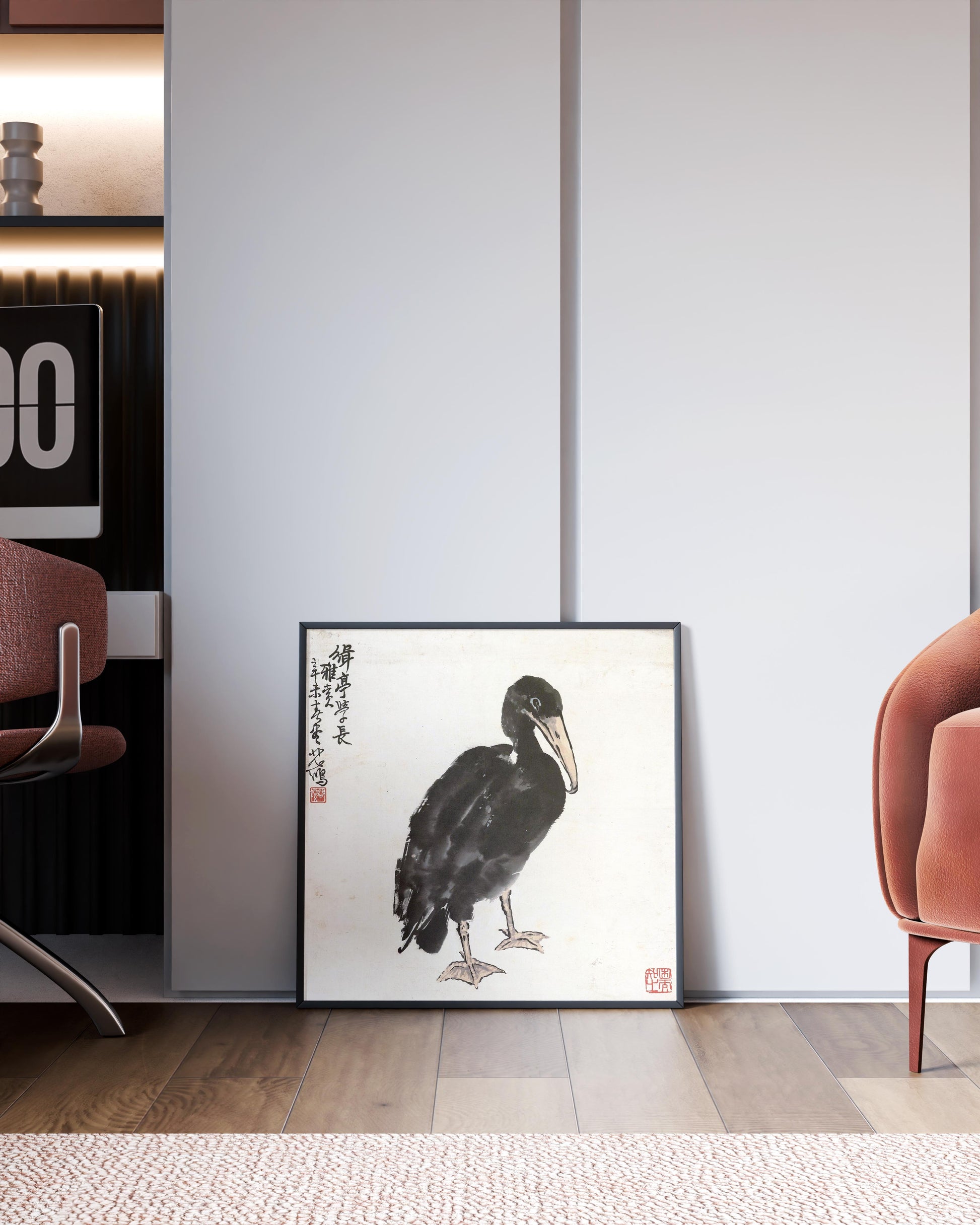A framed Xu Beihong Cormorant art print leaning against a white wall in a modern home office setting. The giclée print of the Chinese ink wash painting adds a touch of classic fine art to the contemporary interior design.
