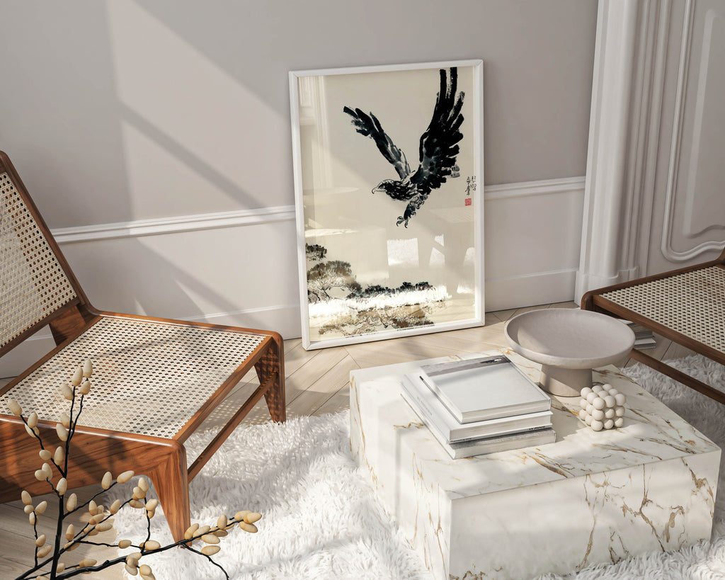 A framed Xu Beihong "The Pine and the Eagle" fine art print leaning on a wall in a modern living room setting.