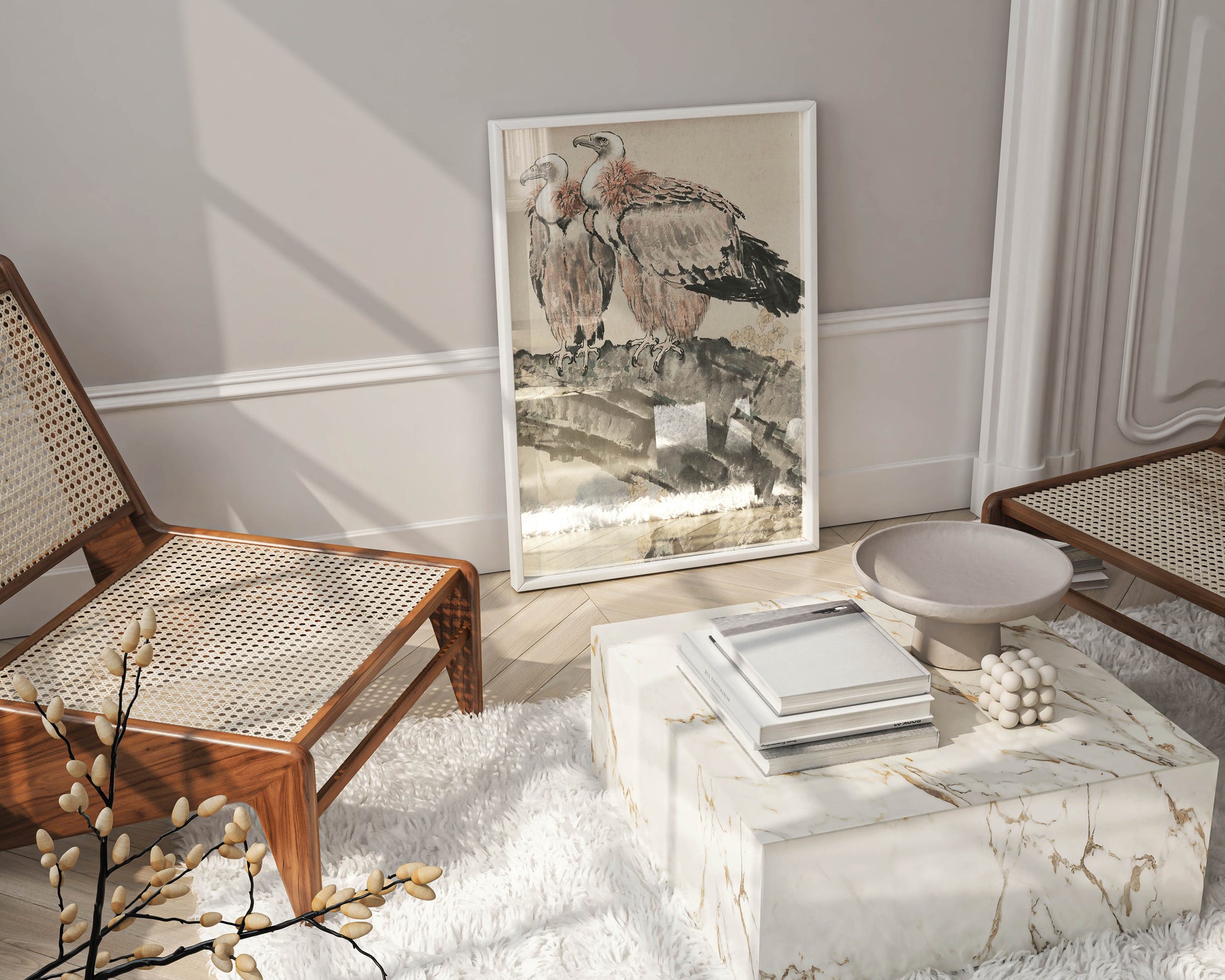 A white-framed art print of Xu Beihong's "Two Condors" leaning against a wall in a stylish living room, next to a marble coffee table and cane chairs, showcasing a modern way to display fine art prints and elevate home decor.