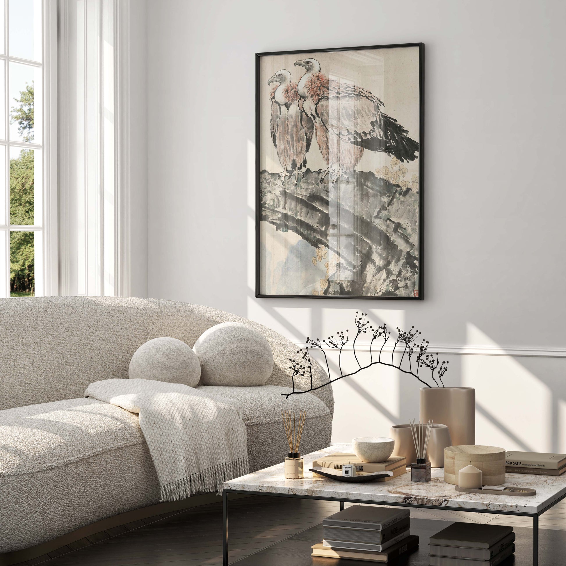 A framed art print of Xu Beihong's "Two Condors" painting hanging above a beige sofa in a minimalist living room, showcasing the print as a stylish and iconic piece of wall art for modern home decor.